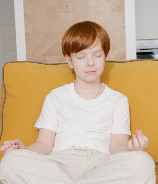 Child sitting calmly in a simple meditation pose.