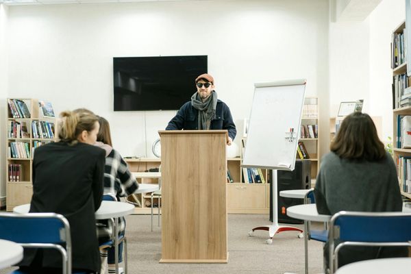 Instructor reading a book to a group of engaged children.